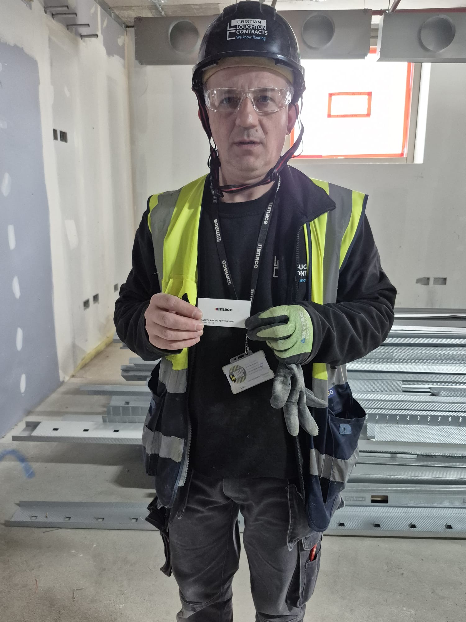 A Loughton Contracts Team Member holding a green card at the UCL ION project.